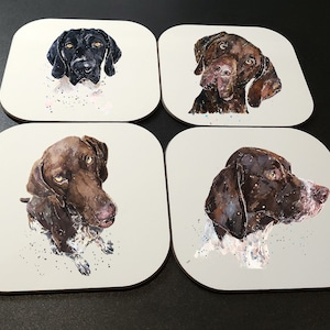 May include: Set of four coasters featuring watercolor illustrations of German Shorthaired Pointers. Each coaster depicts a different pose of the dog, with a white background and subtle speckles.
