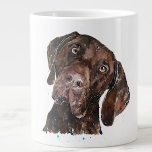 May include: A watercolor painting of a brown dog's head on a white mug. The dog has brown fur and brown eyes. The background is white with blue and red paint splatters.
