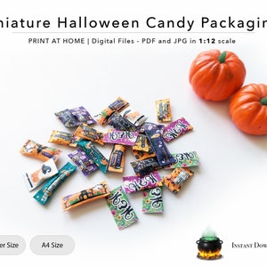Puede incluir: Una colección de envoltorios de caramelos de Halloween en miniatura impresos con varios diseños espeluznantes, que incluyen fantasmas, calabazas y murciélagos. Los envoltorios están esparcidos sobre una superficie blanca, junto con dos calabazas en miniatura.