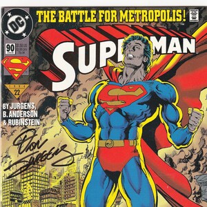 May include: A Superman comic book, issue number 90, titled The Battle for Metropolis. The cover features Superman in his blue, red, and yellow suit standing amidst city rubble. The cover includes text, issue details, and a signature by Dan Jurgens.