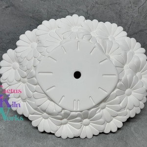 Puede incluir: Cara de reloj de cerámica blanca con un diseño de margarita en relieve. La cara del reloj está en blanco y lista para ser pintada.