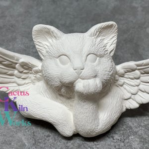 May include: White ceramic figurine of a cat with wings. The cat is sitting with its paws tucked in and has a sweet expression on its face. The wings are detailed and have a feathery texture.