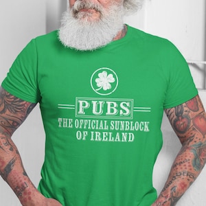 May include: A man wearing a green t-shirt with a white shamrock and the text "Pubs - The Official Sunblock of Ireland".
