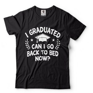 以下が含まれることがあります： 白い文字で「I GRADUATED CAN I GO BACK TO BED NOW？」と書かれた黒いTシャツ。卒業キャップ、星、月桂樹の枝のデザイン。ユーモラスな卒業祝いのプレゼントです。