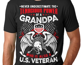 May include: Black t-shirt with a white graphic design featuring an eagle holding American flags and the text "Never underestimate the tenacious power of a grandpa who is also a U.S. veteran."