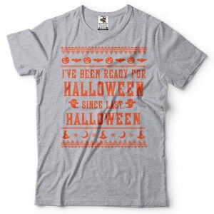 May include: Grey t-shirt with an orange print that says "I've been ready for Halloween since last Halloween". The print has a festive, Christmas jumper-like design with pumpkins, bats, ghosts, and stars.