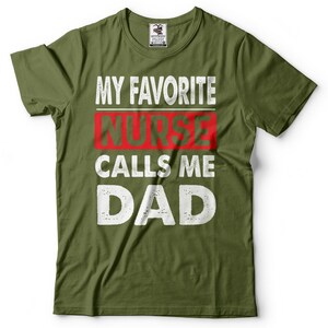 May include: Green t-shirt with white text that reads "My Favorite Nurse Calls Me Dad". The word "Nurse" is in red.