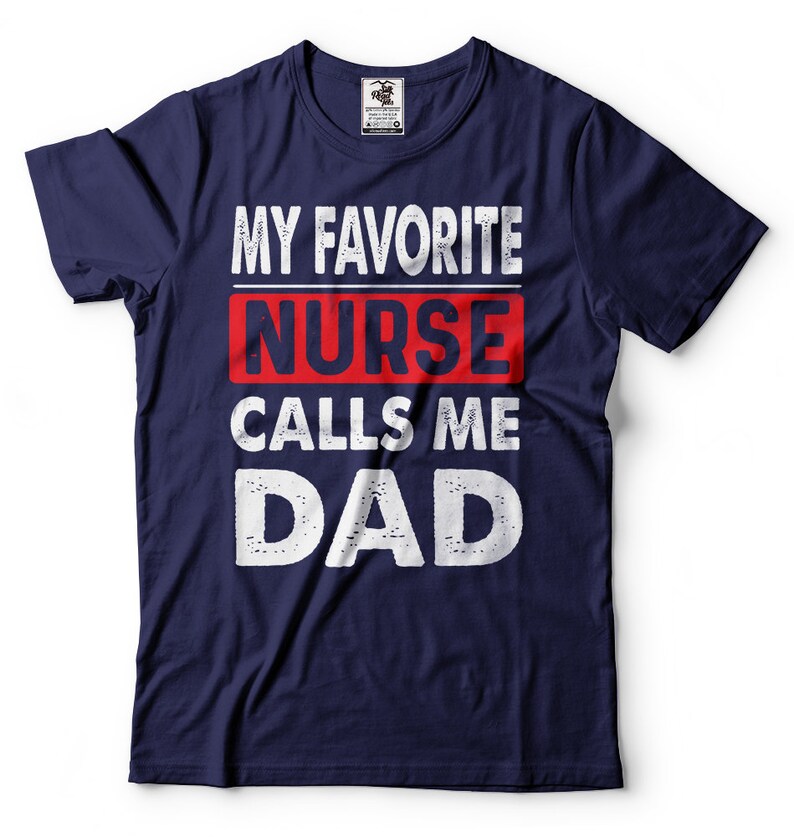 May include: Navy blue t-shirt with white text that reads "My Favorite Nurse Calls Me Dad". The word "Nurse" is in red.