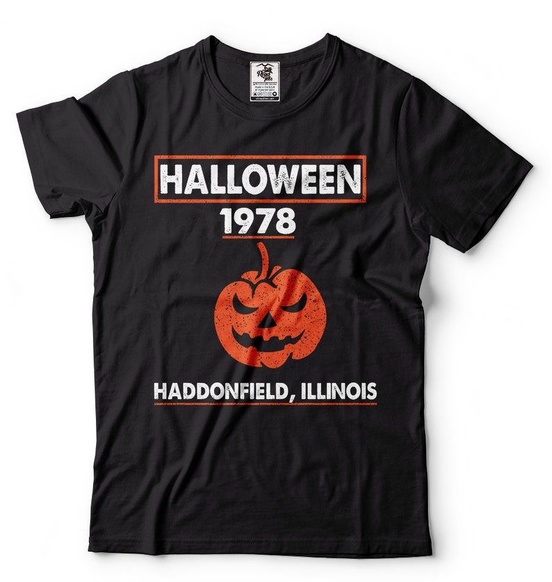 K&ouml;nnte beinhalten: Schwarzes T-Shirt mit einer wei&szlig;en Grafik, auf der "HALLOWEEN 1978" mit einem K&uuml;rbis in der Mitte und "HADDONFIELD, ILLINOIS" unter dem K&uuml;rbis steht.