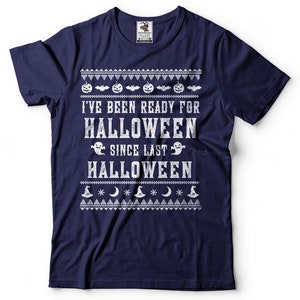 May include: Navy blue t-shirt with a white distressed graphic that reads "I've been ready for Halloween since last Halloween". The graphic is surrounded by a white pattern of pumpkins, bats, ghosts, moons, and witch hats.