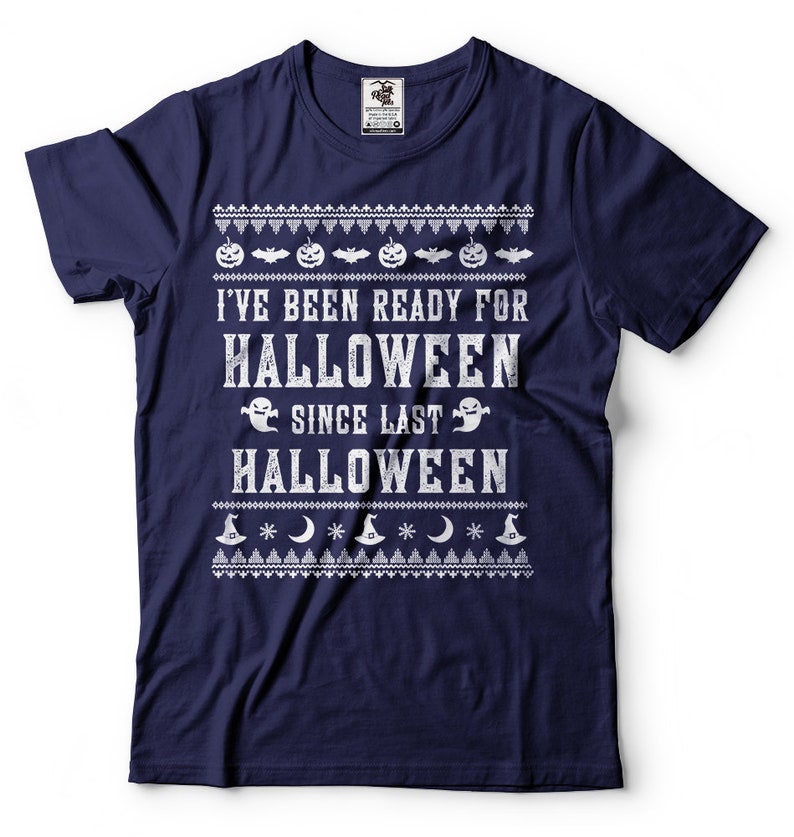 May include: Navy blue t-shirt with a white distressed graphic that reads "I've been ready for Halloween since last Halloween". The graphic is surrounded by a white pattern of pumpkins, bats, ghosts, moons, and witch hats.