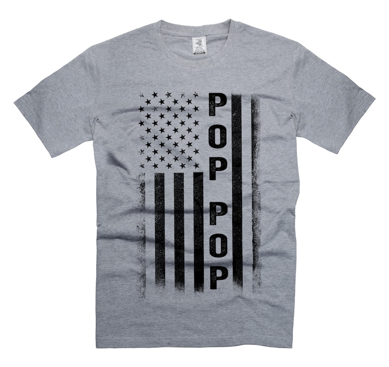 May include: A grey t-shirt with a distressed American flag design and the word "POP" written vertically in black.