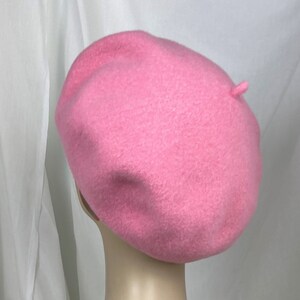 May include: A pink wool beret. The beret is a classic style with a simple design.