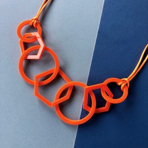 Fel oranje moderne zeshoek en cirkel geometrische acryl ketting uit het midden van de eeuw.