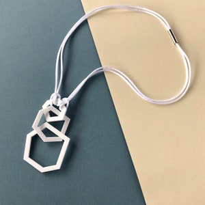 Contemporary white geometric acrylic pendant necklace.