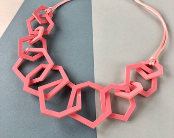 Coral pink chunky geometric mid-length modern necklace.