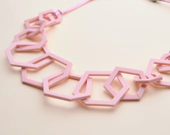 Collier moderne mi-long géométrique épais rose pâle.