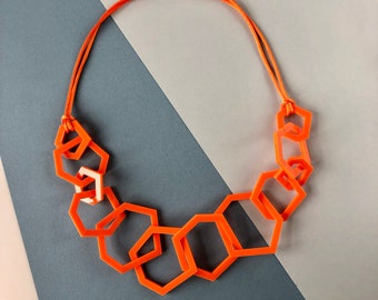 Bright orange chunky geometric statement necklace.