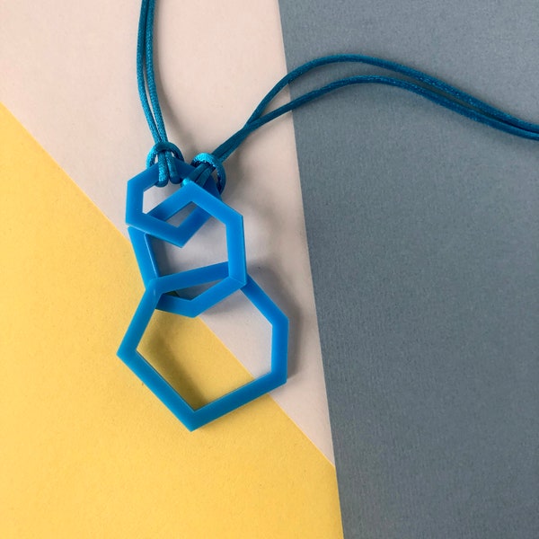 Collier acrylique bleu ciel avec pendentif géométrique.