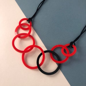 Red and black round link mid-length acrylic necklace.