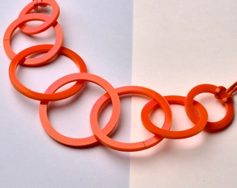 Bright orange circle link mid-length acrylic necklace.
