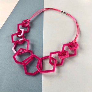 Fuchsia pink geometric mid-length acrylic necklace.