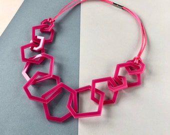 Fuchsia pink geometric mid-length acrylic necklace.