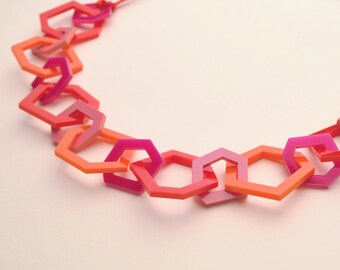 Multi red and pink geometric chain link acrylic necklace.