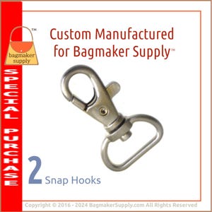 May include: Two silver snap hooks, a type of metal clasp used for attaching straps or other accessories to bags or other items. The hooks are shown against a white background. The text "Custom Manufactured for Bagmaker Supply™" is visible above the hooks.