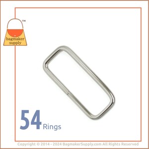 May include: A pack of 54 silver metal rings. The rings are rectangular in shape and have a smooth finish.