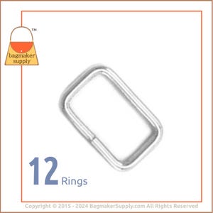May include: A close-up of a silver metal ring, 12 rings in total. The ring is rectangular in shape and has a smooth finish. The image includes the text "12 Rings".