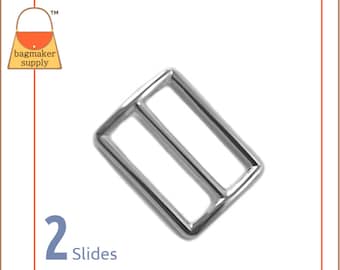 May include: Silver metal slider buckle with two slides. The buckle is rectangular with rounded corners. The buckle is designed to be used with a strap or belt.
