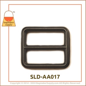 May include: A dark grey rectangular slider buckle with two parallel bars. The product code "SLD-AA017" is printed below the buckle. The "bagmaker supply" logo is in the upper left corner. Ideal for bag making.