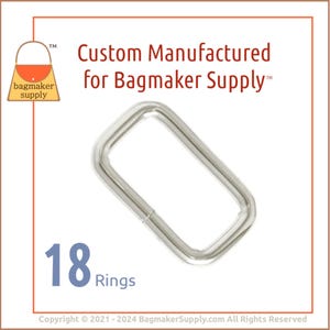 May include: A set of 18 silver metal rings, each with a rectangular shape. The rings are designed for use in crafting and bag making.