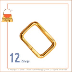 May include: Twelve gold metal rings, each with a rectangular shape. The rings are approximately 1 inch in length and 1/2 inch in width.