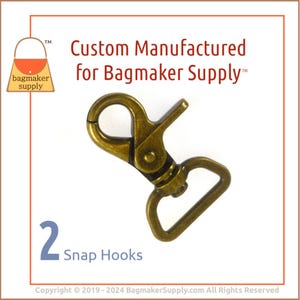 May include: Two gold-toned metal snap hooks. The hooks are designed for attaching to bags or other accessories. The text "Custom Manufactured for Bagmaker Supply™" is visible in the image.