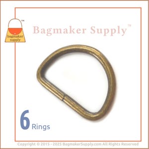 May include: Six antique brass D-rings, each measuring approximately 1 inch in diameter. The rings are ideal for crafting bags, purses, and other leather goods.