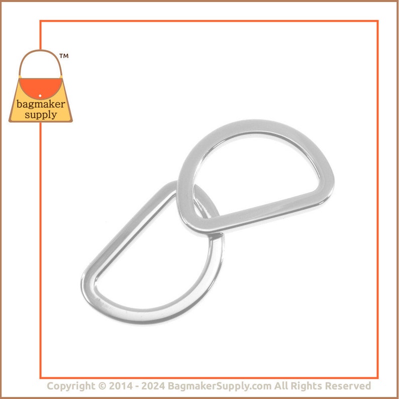 May include: Two silver metal D-rings, one larger than the other, are stacked on top of each other. The rings are smooth and shiny.