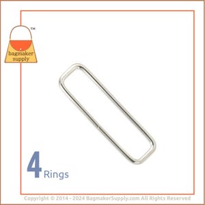 May include: Four silver metal rings, each with a rectangular shape. The rings are ideal for attaching to bags, purses, or other accessories.