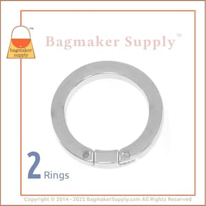 May include: Two silver metal rings with a snap closure. The rings are approximately 1 inch in diameter.