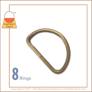 May include: Eight gold-toned metal D-rings. The rings are approximately 1 inch in diameter.