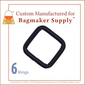 Puede incluir: Seis anillos en D de metal negro. Los anillos son de forma cuadrada y tienen un acabado liso. El texto "Custom Manufactured for Bagmaker Supply" está impreso en la imagen.