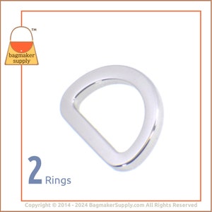 May include: Two silver D-rings, a type of metal hardware used in crafting and sewing projects. The rings are shown against a white background.