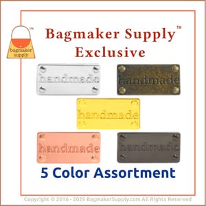 May include: A 5-color assortment of rectangular metal tags with the word "handmade" embossed on each. The tags are in silver, bronze, gold, copper, and dark gray. The image includes the text "Bagmaker Supply Exclusive" and "5 Color Assortment".