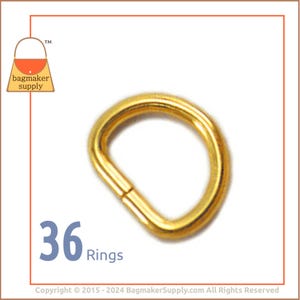 May include: A pack of 36 gold-colored metal D-rings. The rings are approximately 1 inch in diameter. The image shows a close-up of one ring.