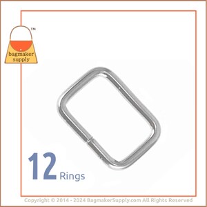 May include: Twelve silver metal rings, each with a rectangular shape. The rings are ideal for attaching to straps, handles, or other accessories.