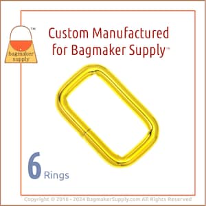 May include: Six gold metal rings, each with a rectangular shape. The rings are custom manufactured for Bagmaker Supply.