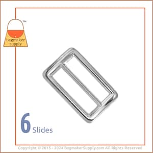May include: Silver metal slider buckle for a strap or belt. The buckle is rectangular with a single slot in the center. The text "6 Slides" is printed below the buckle.