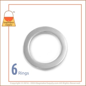 May include: Six silver metal rings, each with a smooth, rounded edge. The rings are approximately 1 inch in diameter.