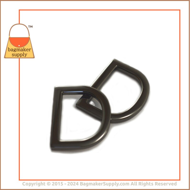 May include: Two black metal D-rings with a teardrop shape. The rings are interlocked.
